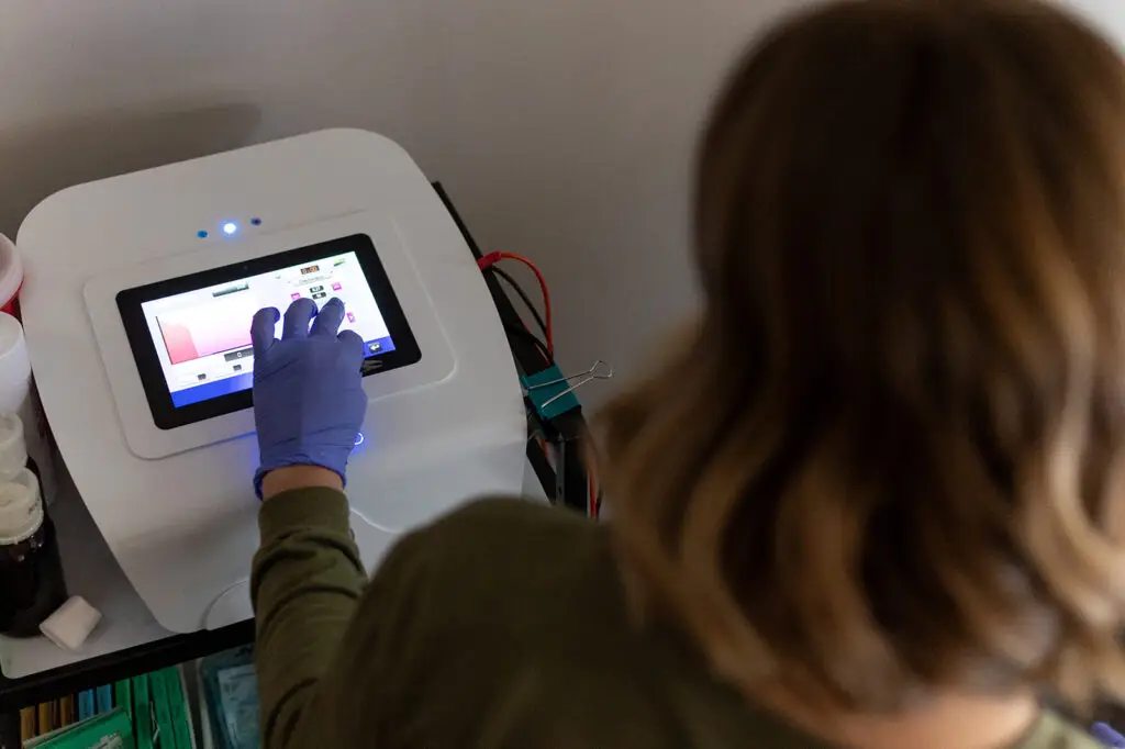 An employee of Ober Yahr Electrolysis using a touch screen device during the electrolysis process